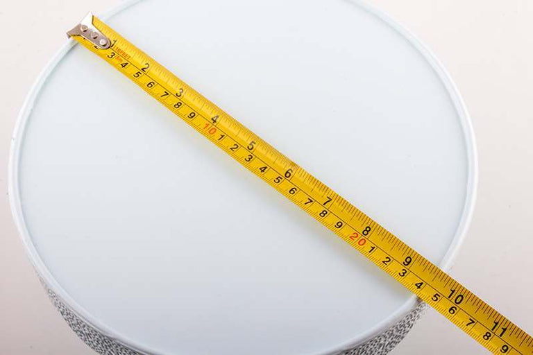 Yellow measuring tape on a white cake stand