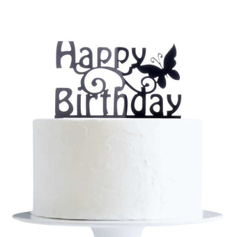 Black 'Happy Birthday' cake topper with a butterfly on a white cake.