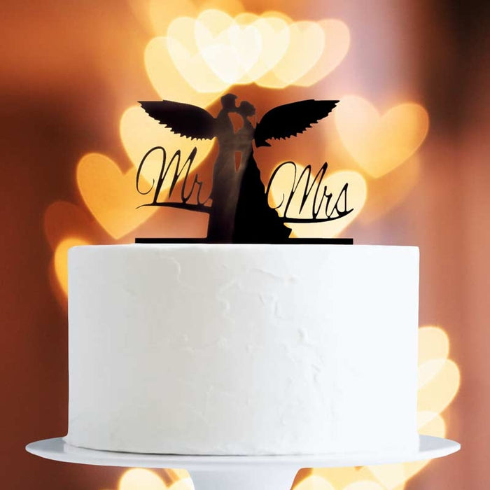 White cake with 'Mr' and 'Mrs' cake topper against a warm, blurred background