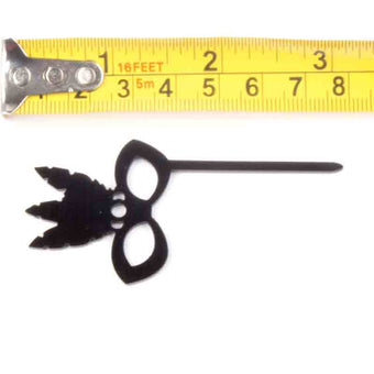 Black decorative item with a measuring tape for scale on a white background