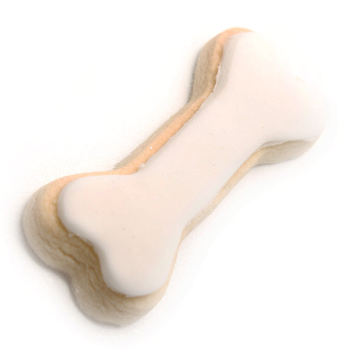 Dog bone-shaped cookie with white icing on a white background