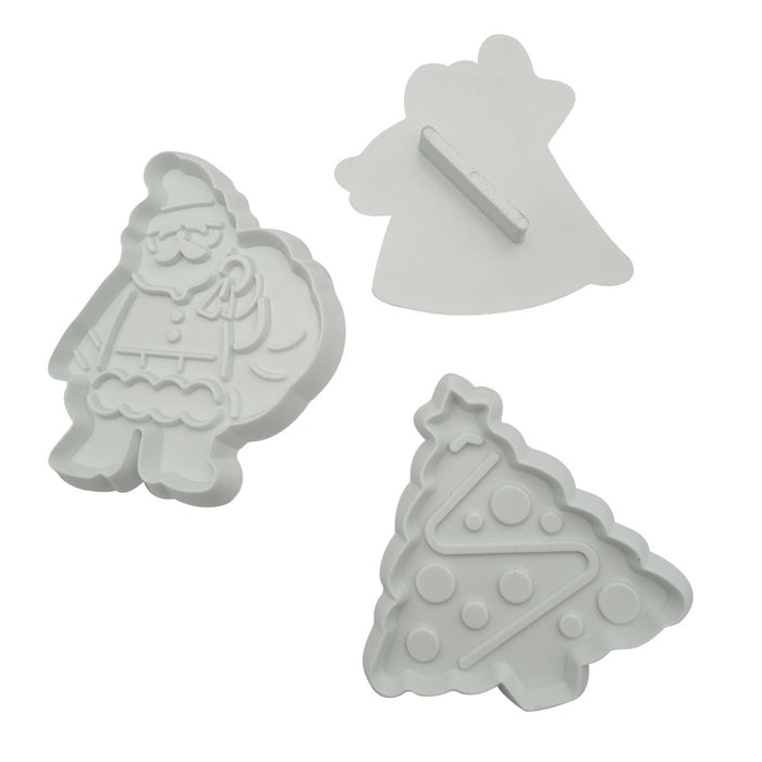 Three white cookie cutters shaped like a Tree, a Angel, and Santa on a white background.