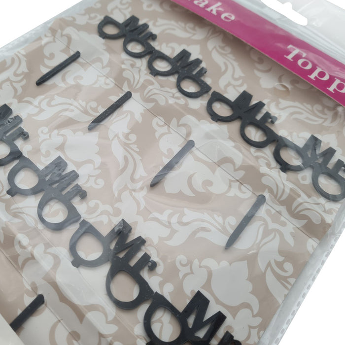 Packaged cake toppers with decorative text on a patterned background