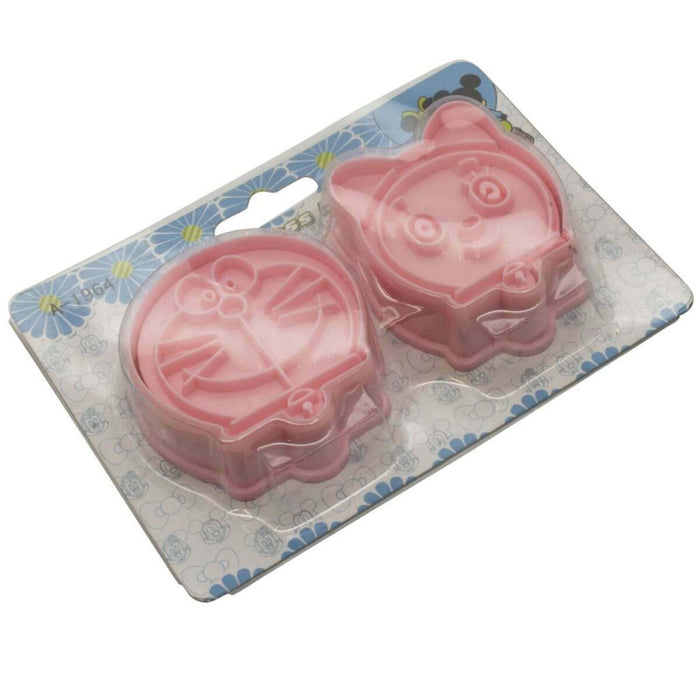 Two pink cookie cutters shaped like cartoon characters on a decorative card.
