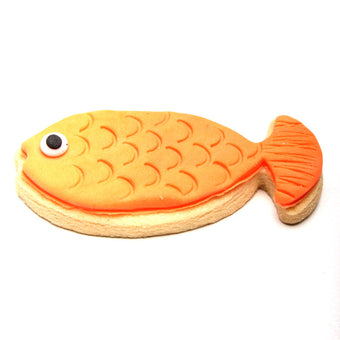 Fish-shaped cookie with orange body and black eye on a white background