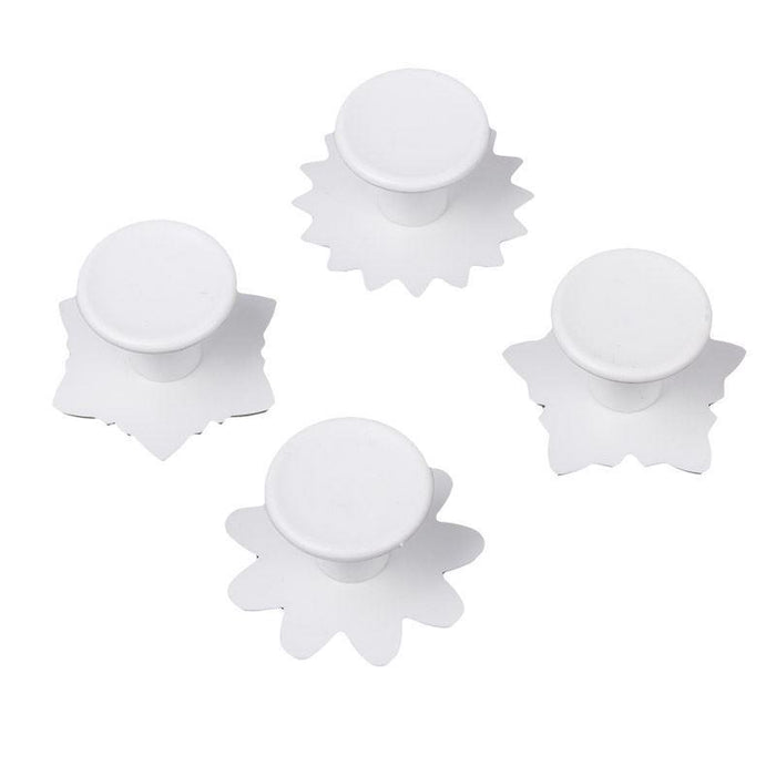 Four white floral fondant veiner on a white background