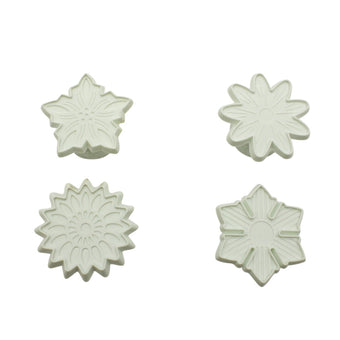 Four white floral-shaped fondant veiners on a white background