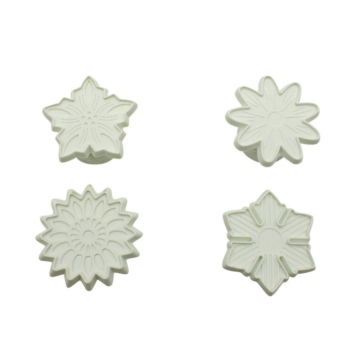 Four white floral-shaped fondant veiners on a white background