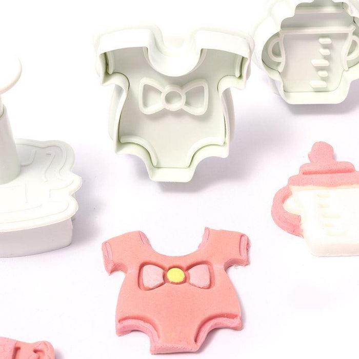 Plunger cutters shaped like baby rompers and bottles on a white background