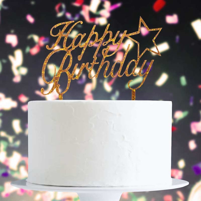 White cake with a gold 'Happy Birthday' topper against a colorful confetti background