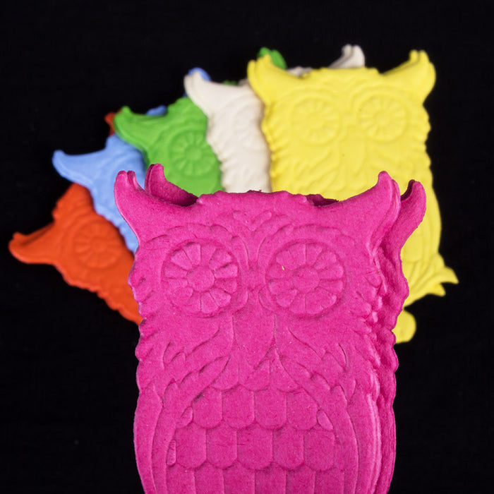 Colorful owl-shaped cake toppers on a black background