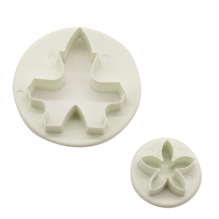 Two white plastic flower fondant cutters on a white background