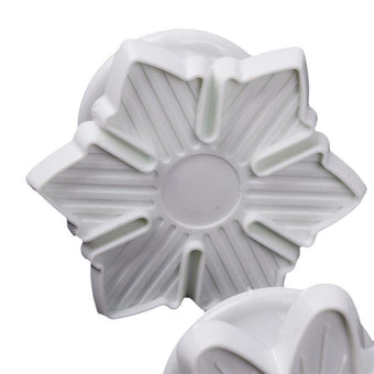 White plastic flower-shaped fondant veiner on a white background