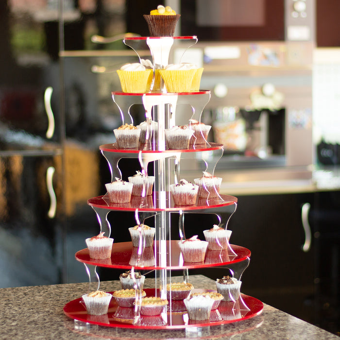 Red tiered cupcake stand with cupcakes on a blurred kitchen background