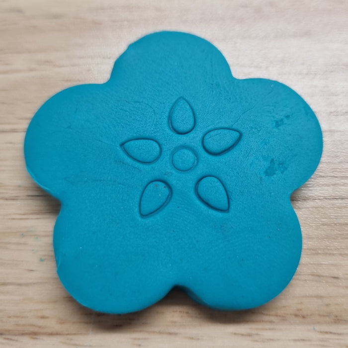 Blue flower-shaped made from flower petal cutter on a wooden surface