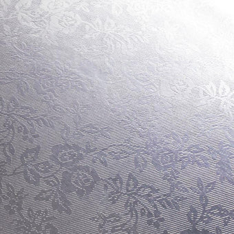 Textured silver foil cake board with a subtle pattern on a white backround