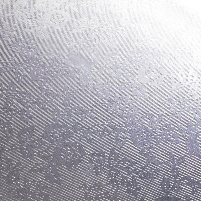 Textured silver foil cake board with a subtle pattern on a white backround