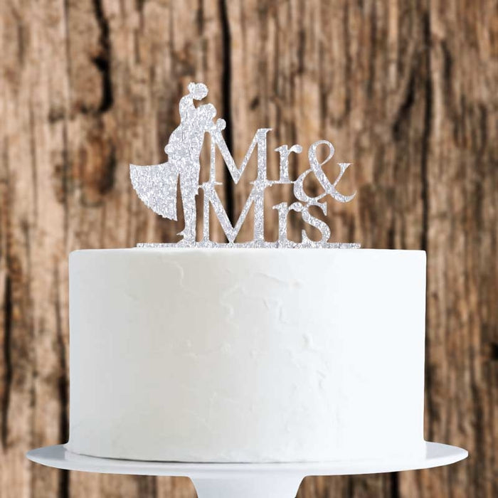 White cake with 'Mr & Mrs' cake topper against a wooden background