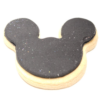 Cookie shaped like a Mickey Mouse head with black and beige colors on a white background