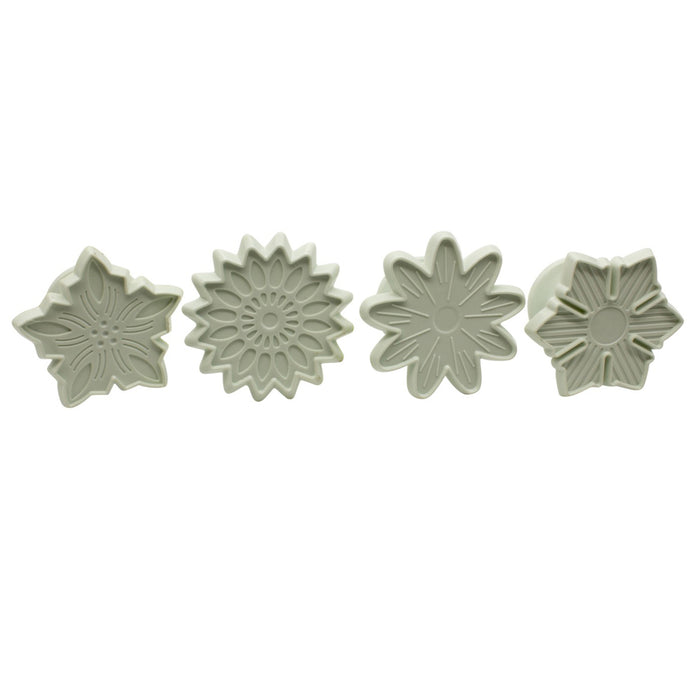 Four white flower-shaped fondant veiners on a white background
