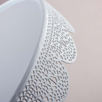 Close-up of a white lace cake stand boarder on a beige background