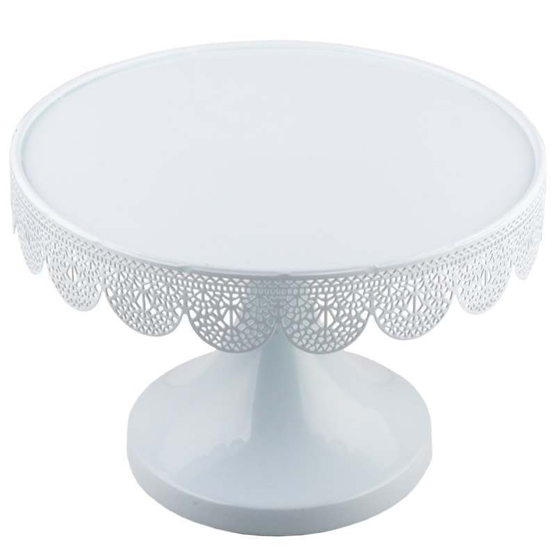 White decorative cake stand with intricate patterns on a white background