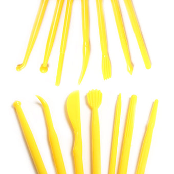 Yellow cake modelling tools on a white background